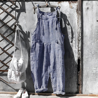 Vintage dark blue and white striped dungarees in a retro jumpsuit overall style, displayed on a clothes hanger.