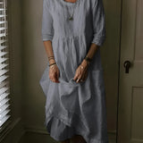Vintage gray linen dress with a loose fit, featuring a collar and long sleeves, displayed in front of a window with blinds.