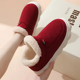 Warm fleece-lined winter slippers for women with a plush collar, being held by a hand showcasing their comfort and soft material.