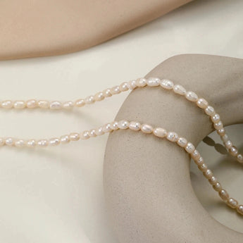 Waterproof hypoallergenic pearl choker necklace on a woman's neck, featuring elegant beach jewelry with a silver chain and metal beads.