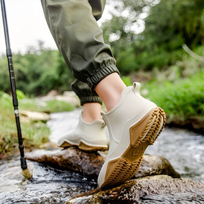 Waterproof lightweight hiking sneakers being worn by a person standing on a grassy area, showcasing their slip-resistant, durable, and quick-dry features.