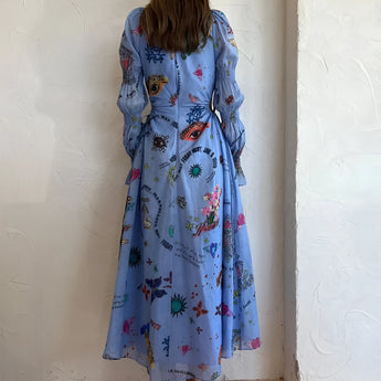 Whimsical blue maxi dress featuring vibrant colorful embroidery and patterns, displayed on a clothes hanger, showcasing its one-piece design with emphasis on the neckline, sleeves, and waist.