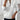 White cable knit zip-up sweater for women in size XXL, featuring a cozy autumn design. The sweater is paired with jeans, showcasing a chic and fashionable look.