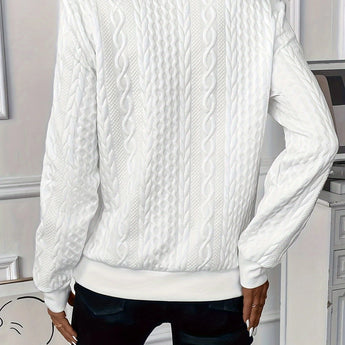 White cable knit zip-up sweater for women styled as an autumn pullover, featuring a cozy design with long sleeves, a high neck, and a soft textured knit pattern. The sweater is paired with black trousers, showcasing a casual yet chic look suitable for cooler weather.