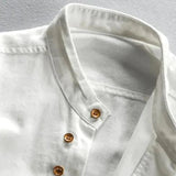 White cotton crew neck shirt with a lightweight and breathable fabric, featuring wooden buttons and a simple design.