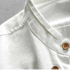 White cotton crew neck shirt featuring lightweight and breathable fabric with distinctive wooden buttons, highlighted by a classic collar and casual short sleeves.