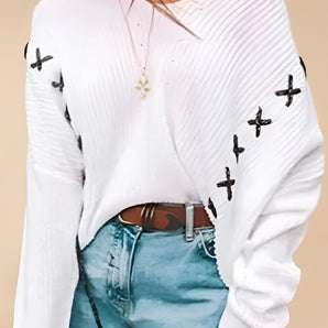 White cross-stitch V-neck sweater with bow-knot detailing, featuring long sleeves and a fitted waist, worn by a woman.