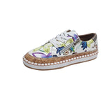 White espadrille sneakers with cork trim and jute-wrapped detailing, designed for summer style and outdoor walking, featuring a fashionable and athletic look.