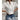 White floral embroidered lace blouse with sheer fabric, modeled with blue jeans, showcasing intricate sleeve and collar details, ideal for summer.