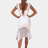 White floral lace V-neck summer dress in bohemian style worn by a woman, showcasing detailed lace patterns and flowing design, highlighting shoulders and arms.
