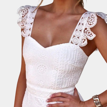 White floral lace dress with V-neck and bohemian style, showcasing delicate shoulder and arm design, fitted waist, and short sleeves.