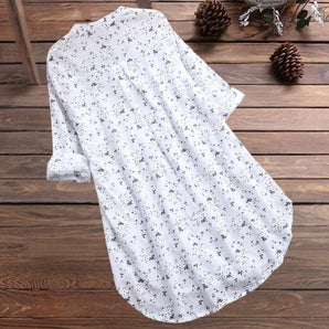 White floral long sleeve tunic dress hanging on a wooden clothes hanger, showcasing its lightweight fabric and elegant design suitable for summer wear.