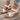 White floral wedge sandals featuring a beaded strap, cutout design, and wedge heel, showcased on a model's foot against a neutral background.