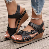 White floral wedge sandals featuring beaded straps and a cutout design.