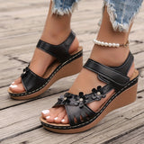 White floral wedge sandals featuring a beaded strap and intricate cutout design.