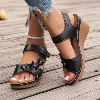 White floral wedge sandals featuring a beaded strap and intricate cutout design.