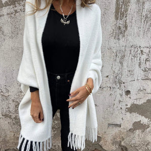 
A stylish women's white fringed cardigan suitable for fall fashion, featuring long sleeves and a collar, worn over a dress shirt.
