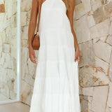 White halterneck tiered midi dress modeled by a fashion model, showcasing the elegant summer resort wear with a focus on the halterneck design, sleeveless style, and fitted waist in a 4XL size.