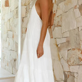 Elegant white halterneck tiered midi dress, featuring a sophisticated design suitable for summer resort wear. The dress is sleeveless, highlighting the shoulders and neck, perfect for bridal parties or elegant occasions.