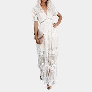 
A white lace maxi dress featuring a bohemian style with a V-neck design, long sleeves, and a fitted waist, ideal for a beach wedding setting.