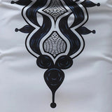 White long-sleeve men's shirt featuring intricately embroidered cuffs and a patterned collar, highlighted with artistic and symmetrical designs.