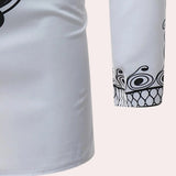 White long-sleeve men's shirt with embroidered cuffs and a patterned collar, displayed on a neutral background, highlighting the intricate detailing on the cuffs and collar.