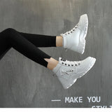 A pair of white platform chunky sneakers with trendy lace-up detail, worn with casual streetwear, showcased on a person standing, highlighting the shoe's design and style.