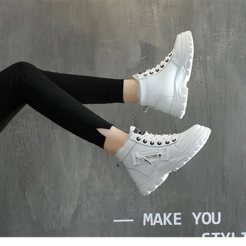 A pair of white platform chunky sneakers with trendy lace-up detail, worn with casual streetwear, showcased on a person standing, highlighting the shoe's design and style.