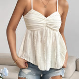 White pleated spaghetti strap camisole styled as a bohemian summer tank top, showcasing its delicate shoulder straps and elegant neckline.
