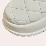 White quilted insulated lightweight winter snow boots on a plain background.