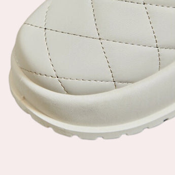 White quilted insulated lightweight winter snow boots on a plain background.