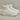 White quilted insulated lightweight winter snow boots displayed on a beige couch, highlighting their comfort and stylish design.