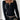 A woman wearing a black ribbed Henley blouse with long fitted sleeves, highlighting the shoulder and neck area, styled in a fashionable manner.