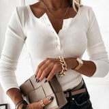 White ribbed Henley blouse for women, featuring a fitted long sleeve design, displayed on a person wearing sunglasses and showcasing the blouse's shoulder and neck details.