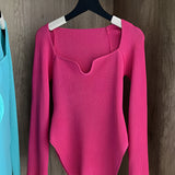 White ribbed scoop neck long sleeve bodysuit in rose color, displayed on a clothes hanger.