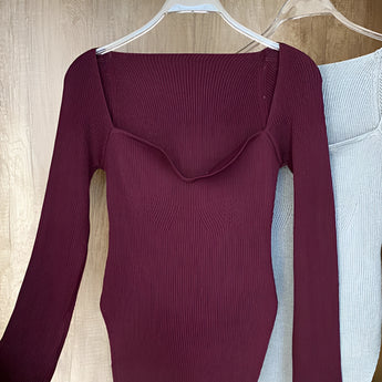 Women's red ribbed scoop neck long sleeve bodysuit displayed on a clothes hanger.