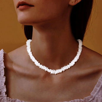 White shell choker necklace worn by a woman, showcasing bohemian beach jewelry style.