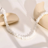 White shell choker necklace with bohemian design, featuring beige and white shells, ideal for beachwear and bridal accessories.