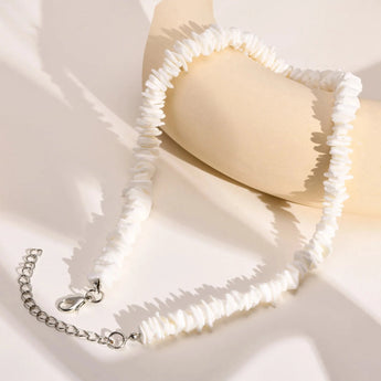 White shell choker necklace with silver accents, bohemian beach jewelry for women, displayed on a light background.