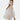 White V-neck midi lace dress with short sleeves, featuring a boho summer style, worn by a woman.