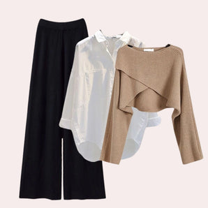 Wide-leg trousers paired with a blouse, designed for women's contemporary office wear, displayed on a clothes hanger.