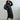 Black windproof women's long winter jacket in size L, featuring a fashionable design. The jacket is lightweight and waterproof, with long sleeves, a defined waist, and extends down to the thighs.