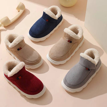 Beige winter slip-on shoes with fleece lining and waterproof exterior, displayed on wooden flooring.