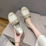 Women's beige beaded slip-on loafers being worn, showcasing elegant summer flats with intricate bead detailing, complemented by a silver sandal-style design.