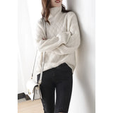 Women's beige chunky knit turtleneck sweater featuring an oversized fit, designed for winter fashion. The sweater showcases a high collar and long sleeves, providing warmth and comfort.