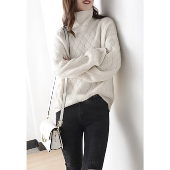 Women's beige chunky knit turtleneck sweater featuring an oversized fit, designed for winter fashion. The sweater showcases a high collar and long sleeves, providing warmth and comfort.