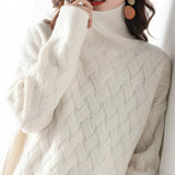 Women's oversized beige chunky knit turtleneck sweater with long sleeves, designed for winter fashion.