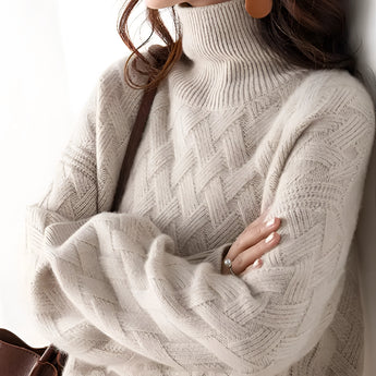 A woman wearing an oversized chunky knit turtleneck sweater in beige, with long sleeves and a relaxed fit, perfect for winter fashion. The sweater appears cozy, with its thick texture, and the turtleneck adds warmth and style.