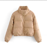 Women's beige cropped puffer jacket with insulated winter style, featuring a fur collar and long sleeves, made from natural materials.