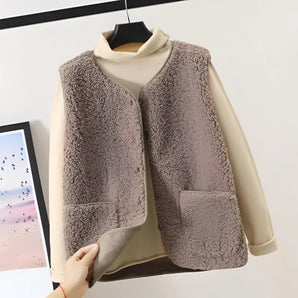 
A women's beige fleece vest designed for cozy winter layering, featuring a sleeveless cut and a persimmon color. The vest is styled on a clothes hanger, showcasing its elegant collar and fashion-forward design.